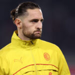 Un joueur de football tenant un chèque de 10 000 euros