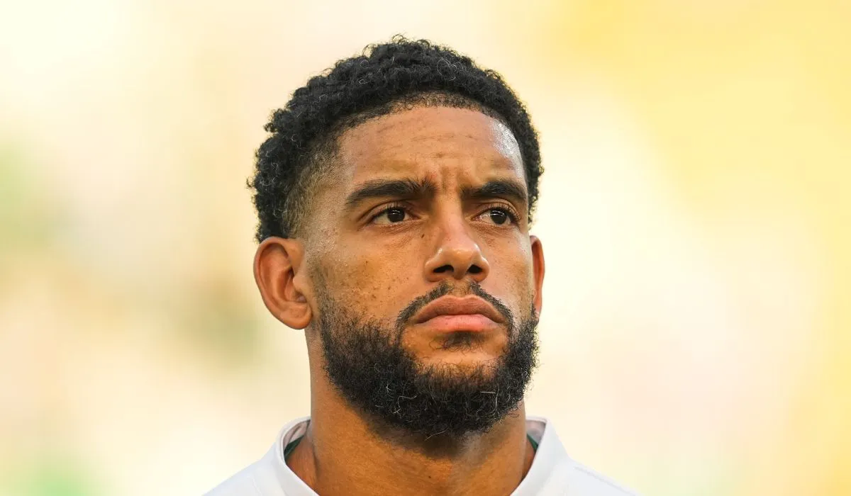 Un joueur de football en tenue d'équipe, avec un doute dans les yeux.