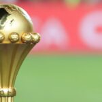 Un combattant de MMA tenant un ticket de pari avec le logo de la CAN 2025.