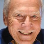 Le champion olympique français Jean Laudet avec la médaille d'or de la course en ligne de 10 000 mètres de canoë biplace.