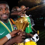 Équipe de football en action, avec des joueurs qui se disputent un ballon.