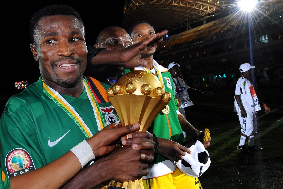 Équipe de football en action, avec des joueurs qui se disputent un ballon.