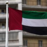 علم الإمارات وعلم روسيا يرفرفان بجانب صورة لمقر رئاسي