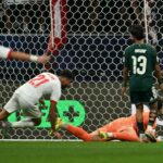 ** صورة للاعبين السعوديين والإماراتيين على أرضية الملعب، مع تجمع المياه حولهم.