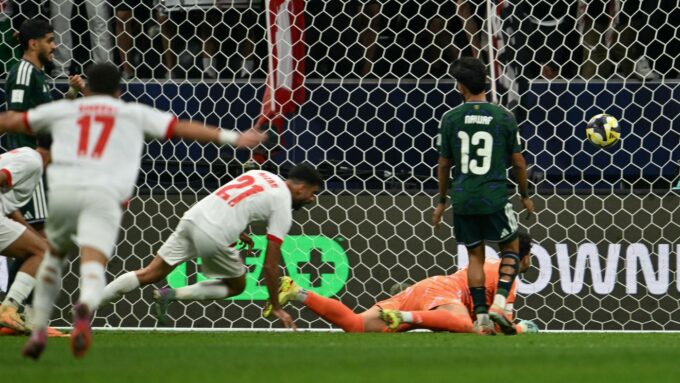 ** صورة للاعبين السعوديين والإماراتيين على أرضية الملعب، مع تجمع المياه حولهم.