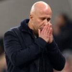 صورة لمدرب ليفربول أرني سلوت يرتدي زي الفريق ويرتدي نظارة.