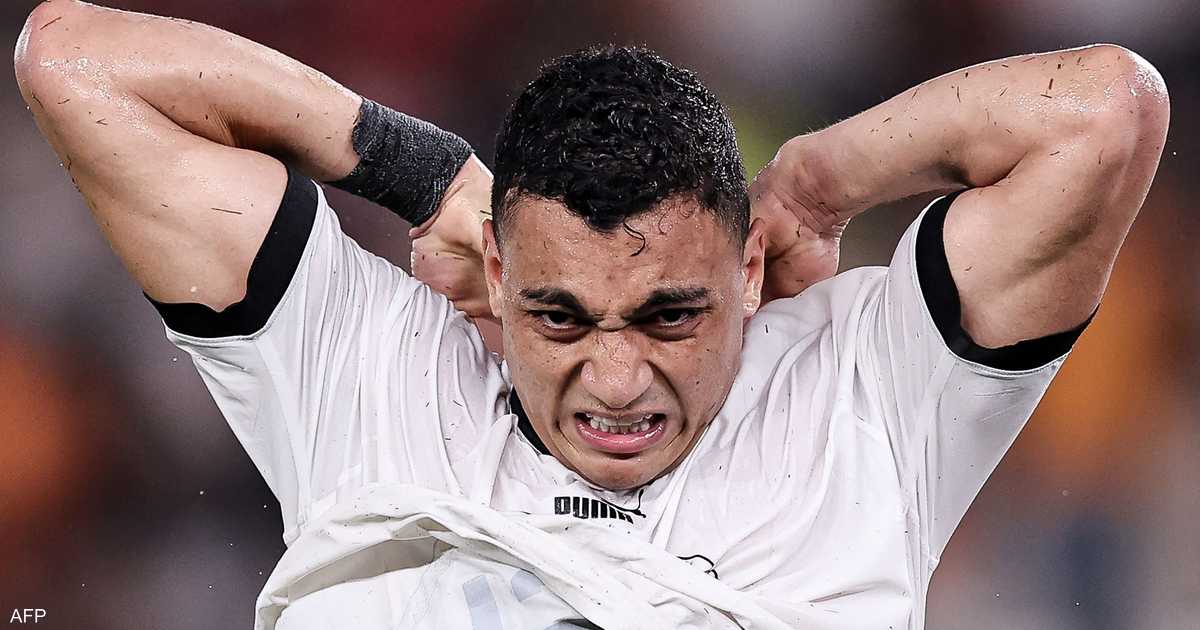 ** صورة لمنتخب مصر في مباراة ضد فريق أجنبي، مع خلفية ملعب رياضي.