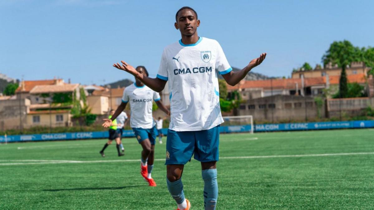 Un jeune joueur de football en action, avec le ballon dans les airs.