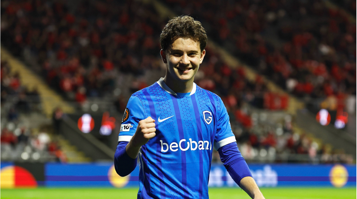 Young footballer in action, with a blurred stadium background.