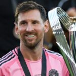 Un joueur de football en action, avec un ballon dans les mains, sous la lumière des projecteurs.