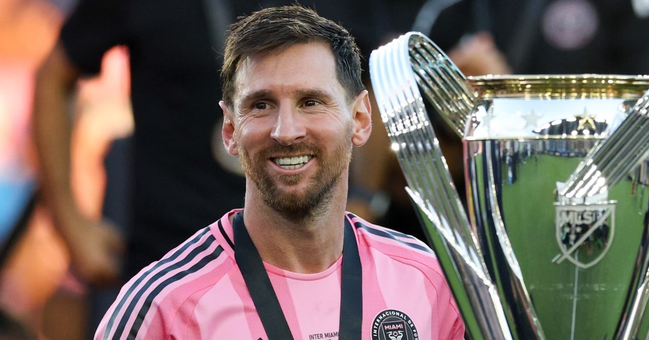 Un joueur de football en action, avec un ballon dans les mains, sous la lumière des projecteurs.