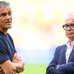 Joueur de football en action, avec le logo du Paris Saint-Germain en arrière-plan.