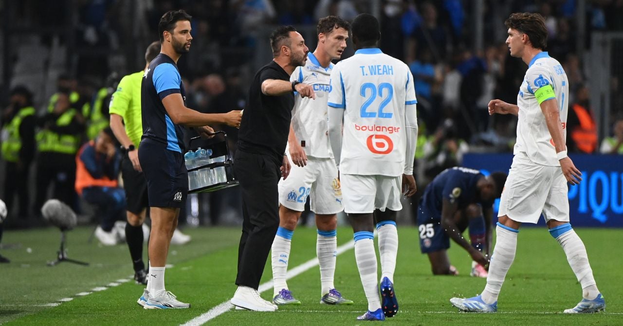 L'entraîneur Roberto De Zerbi et le défenseur central Leonardo Balerdi en discussion sur le terrain.
