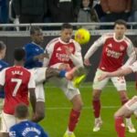 Alt text for the image: "Football players in action, referee consulting VAR"