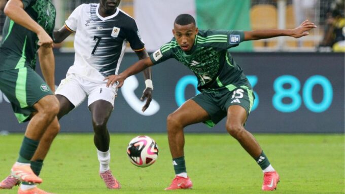 Un joueur de football en action, avec le ballon au pied.