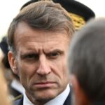 Le président Emmanuel Macron en déplacement à Marseille en décembre 2025, souriant et saluant la foule.