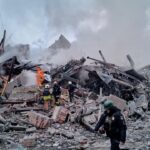 Secouristes et pompiers sur les lieux d'un immeuble résidentiel détruit par une frappe russe à Kharkiv, Ukraine.