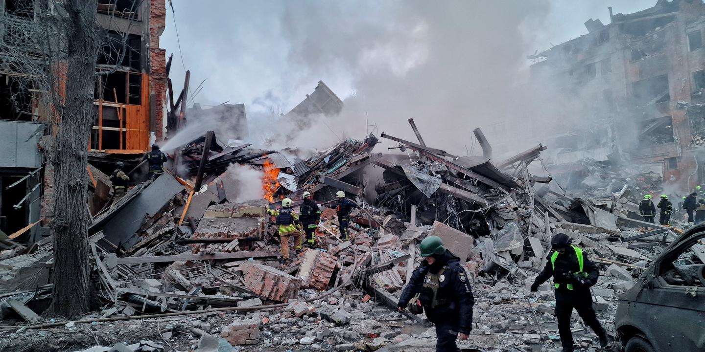 Secouristes et pompiers sur les lieux d'un immeuble résidentiel détruit par une frappe russe à Kharkiv, Ukraine.