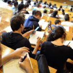 Étudiants en discussion dans un campus universitaire moderne, symbolisant la réforme de l'enseignement supérieur.