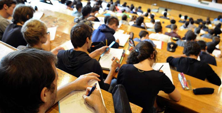 Étudiants en discussion dans un campus universitaire moderne, symbolisant la réforme de l'enseignement supérieur.