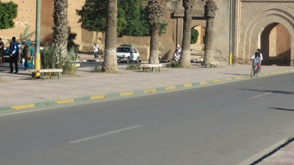 Panneau d'école sous une pluie battante à Taroudant, avec des nuages sombres en arrière-plan.